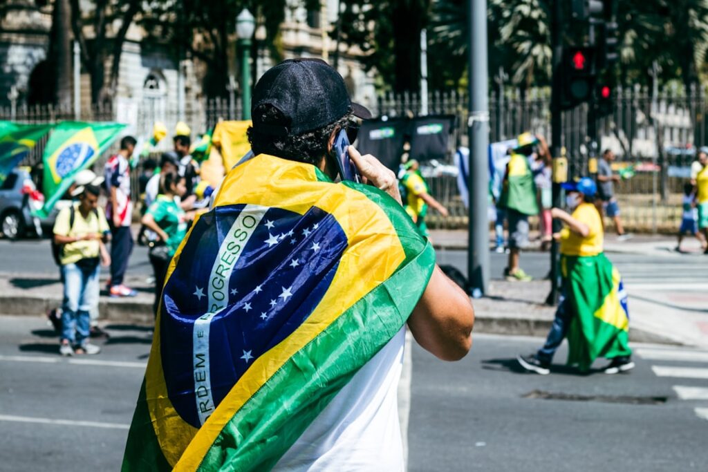 Um Homem Com Uma Bandeira Nas Costas Andando Pela Rua EkBA 7V56uw