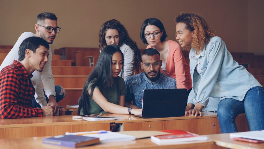 Grupo Diversificado De Alunos Reunidos Em Torno De Um Laptop EA0 iajPYFE