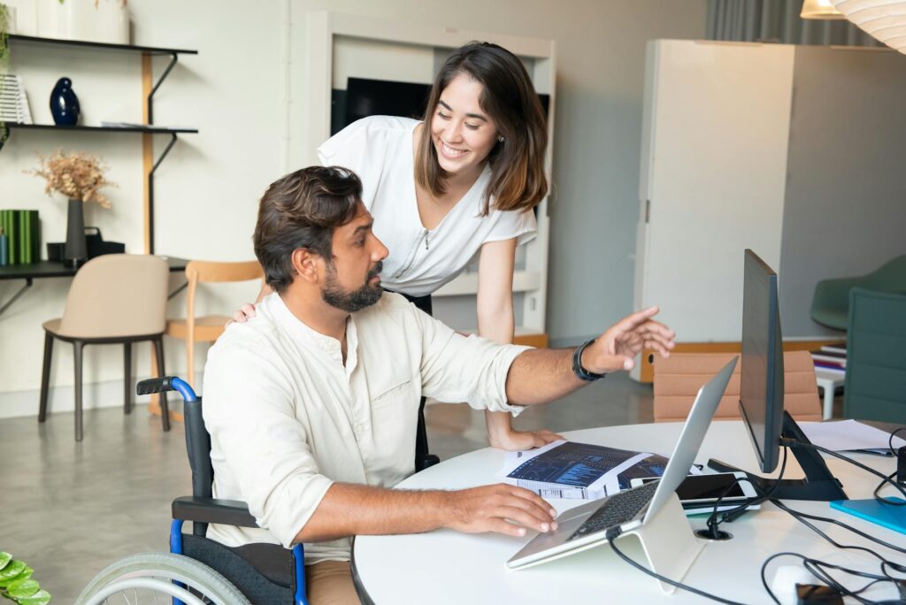Interracial colleagues working together on a project in a modern office setting, showcasing teamwork and inclusivity.